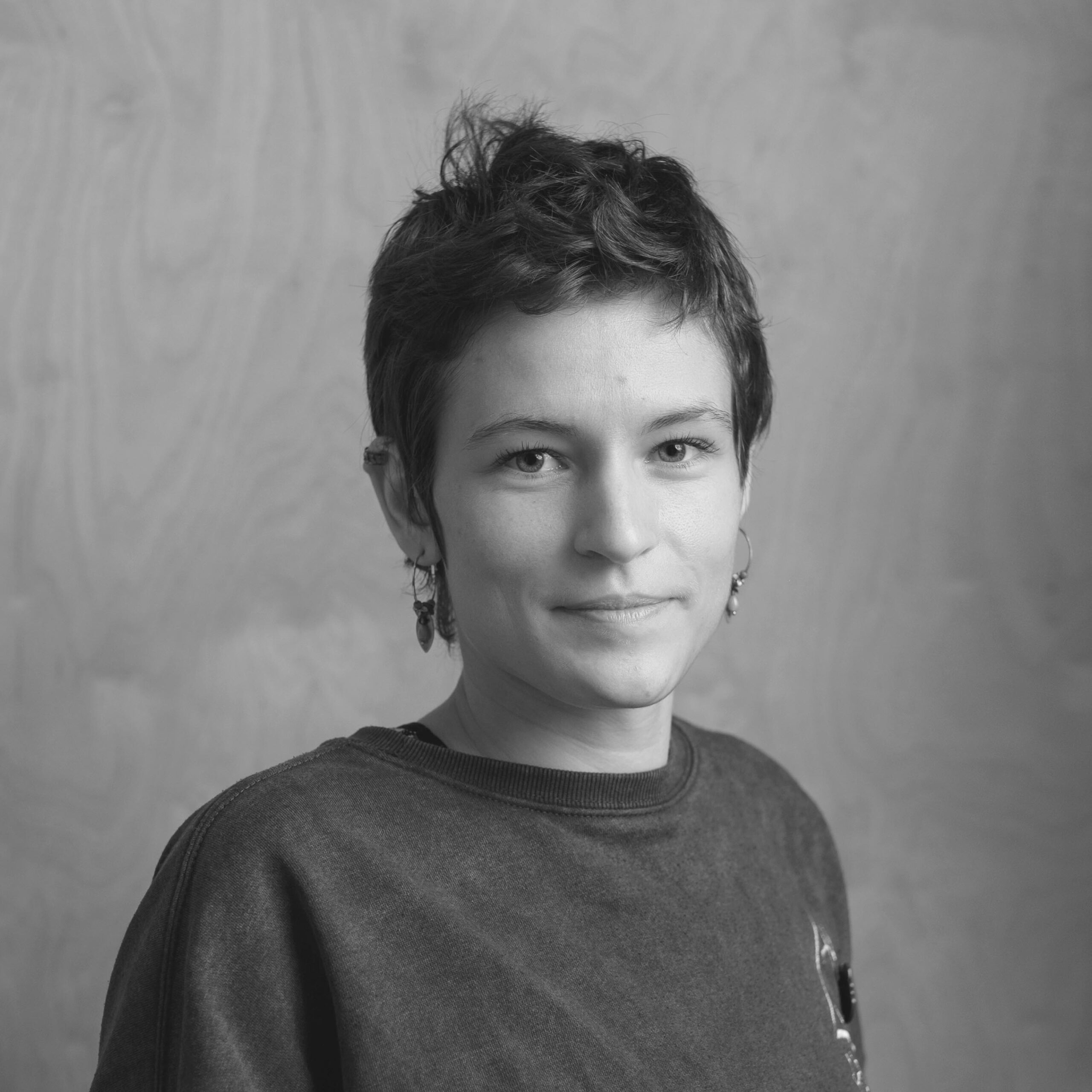 Poză, portret cu Anto zâmbind în tricou cu harry potter. Poza este alb negru