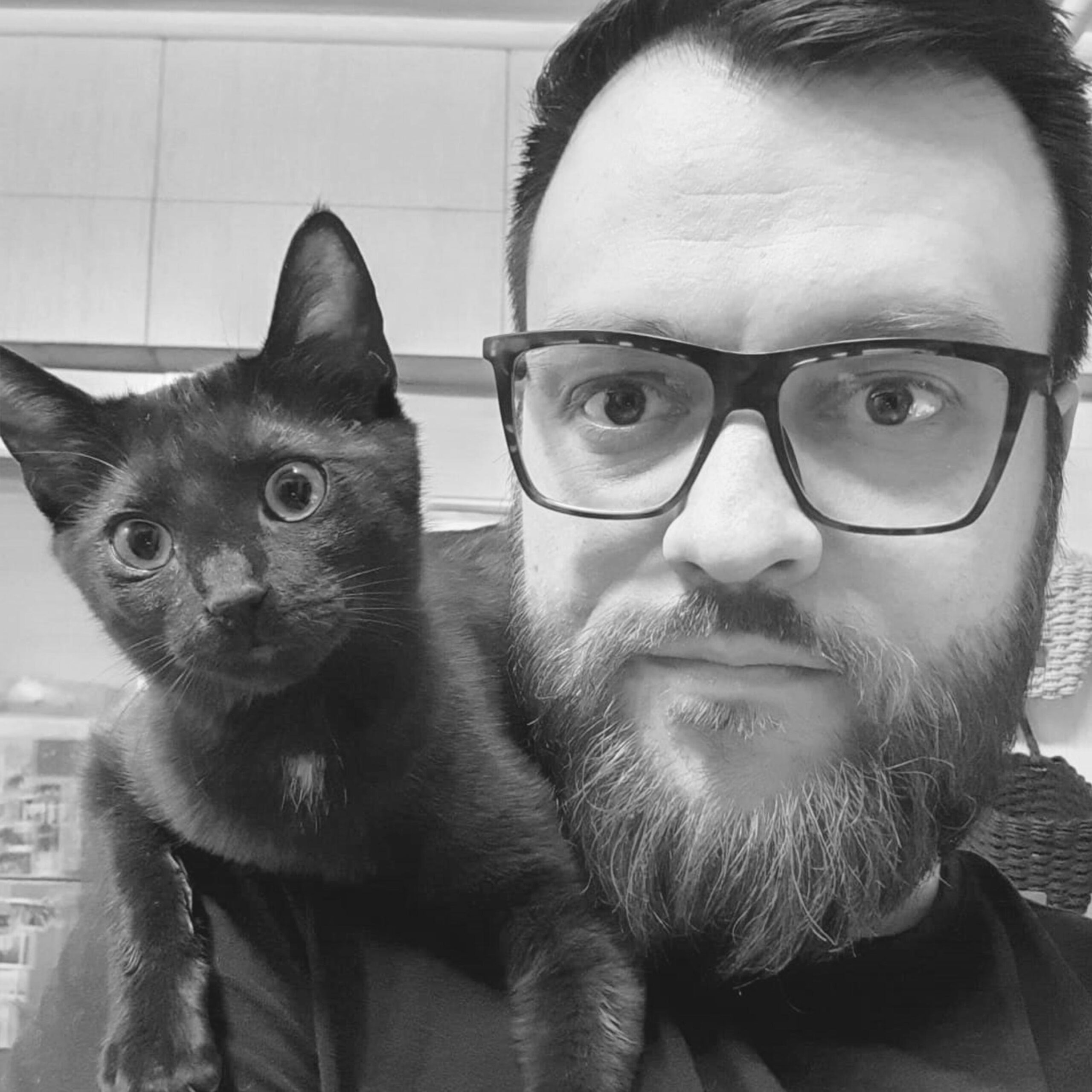 Poză, portret cu Vlad cu pisica lui pe umăr. Poza este alb negru.